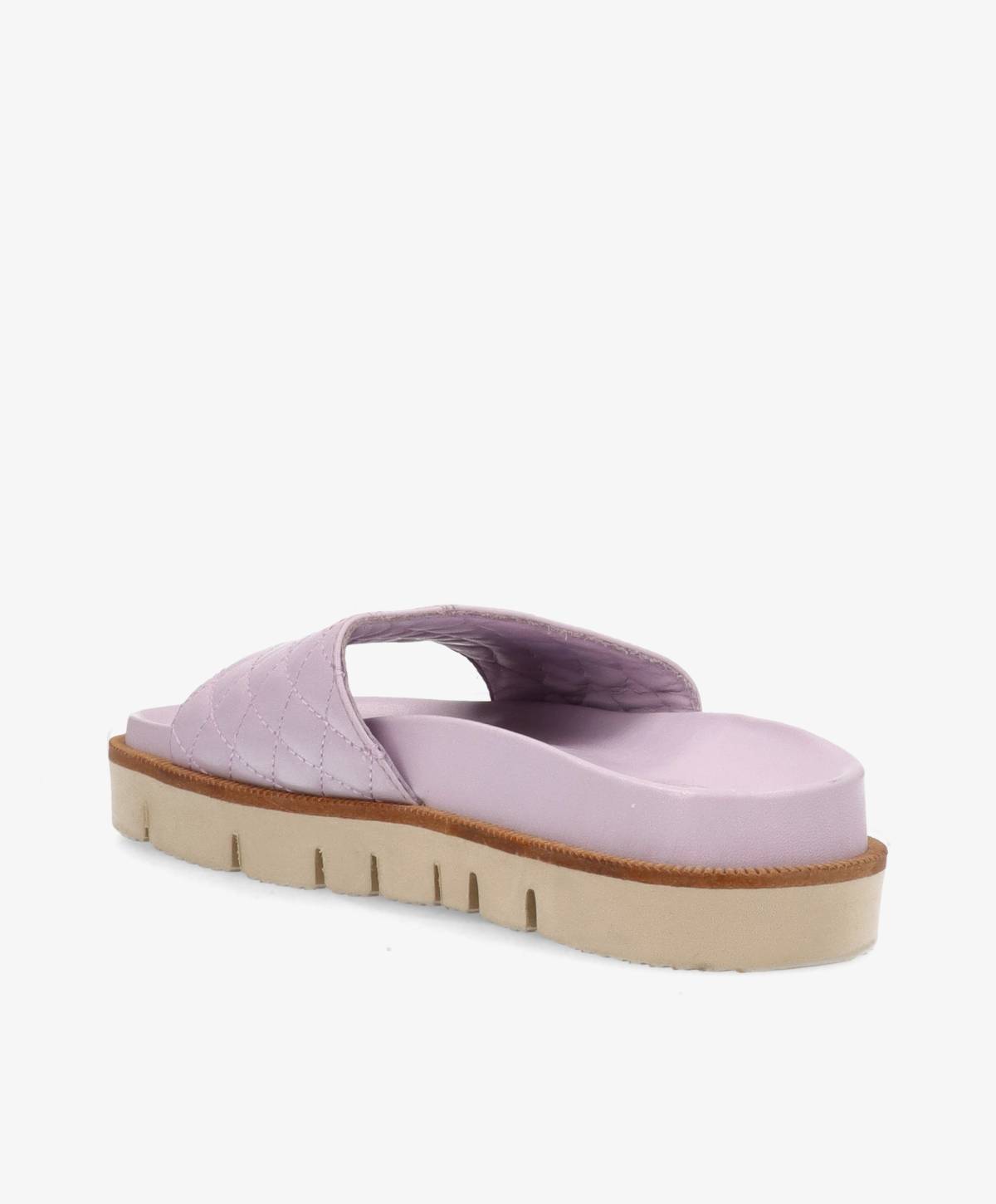 Lyserød sandal med quiltet mønster og tyk, beige sål set fra siden.