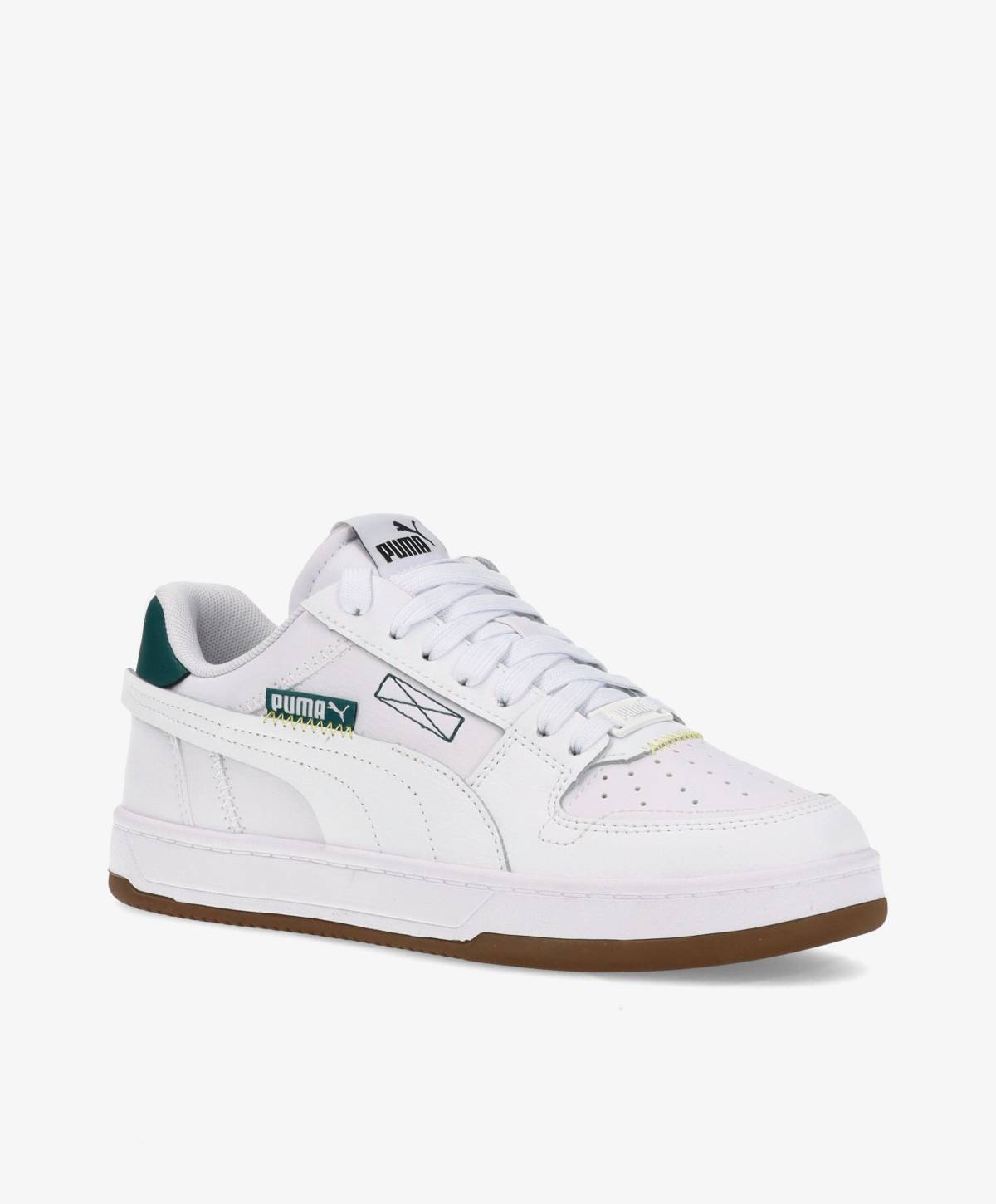 Hvid sneaker med grønne detaljer og brun sål, mærket Puma.