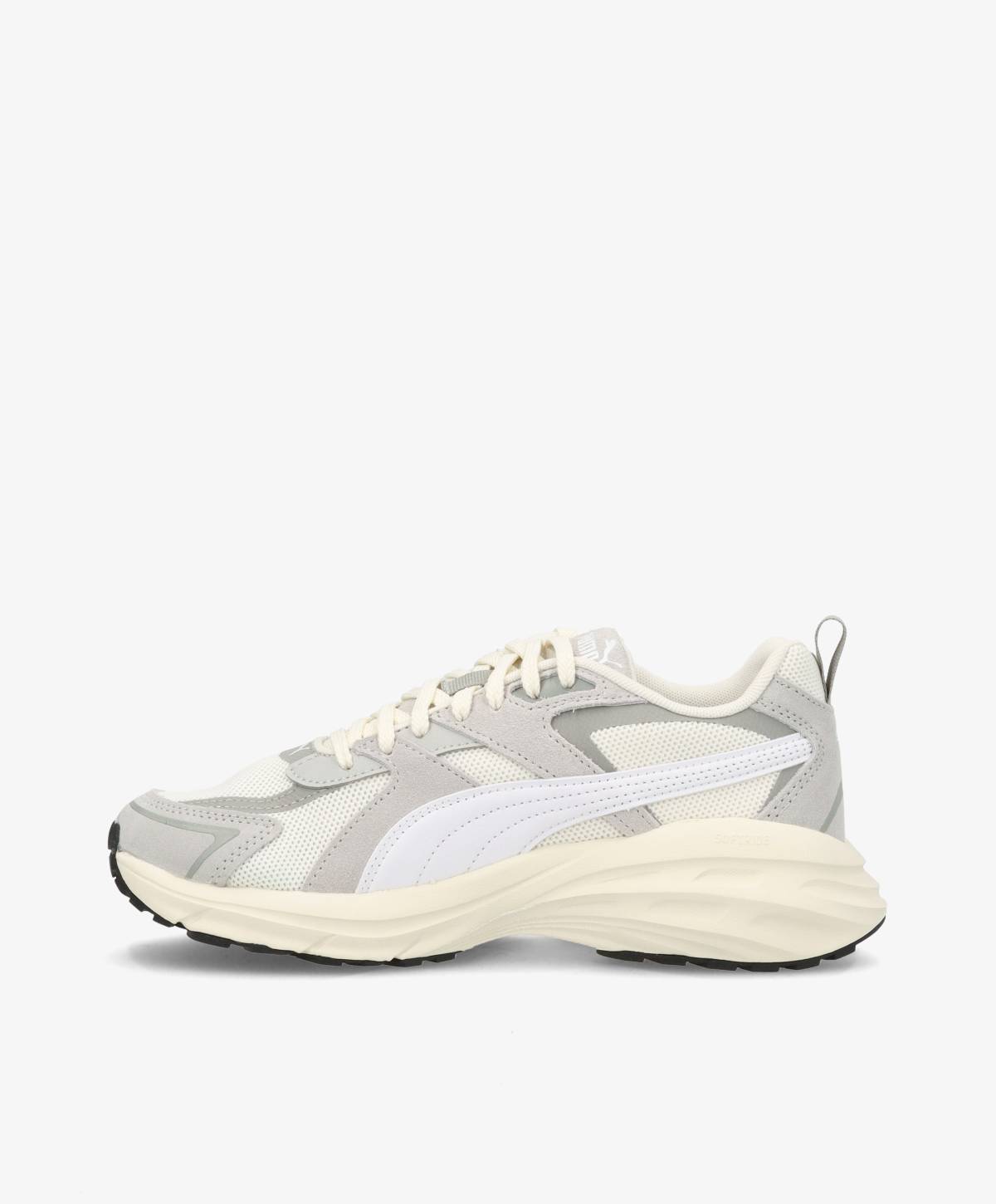 Grå og hvide sneakers med snørebånd og en tyk sål, set fra siden mod en hvid baggrund.
