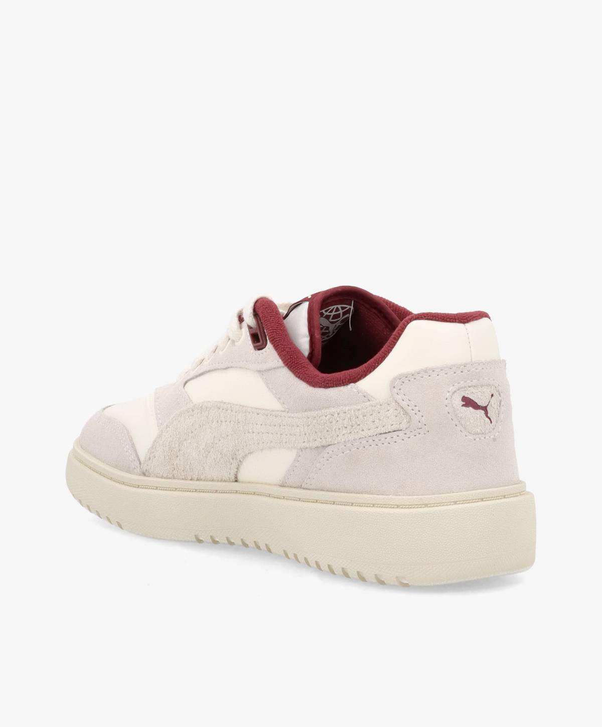 En hvid og beige sneaker med røde detaljer og Puma-logo på hælen, set fra siden.