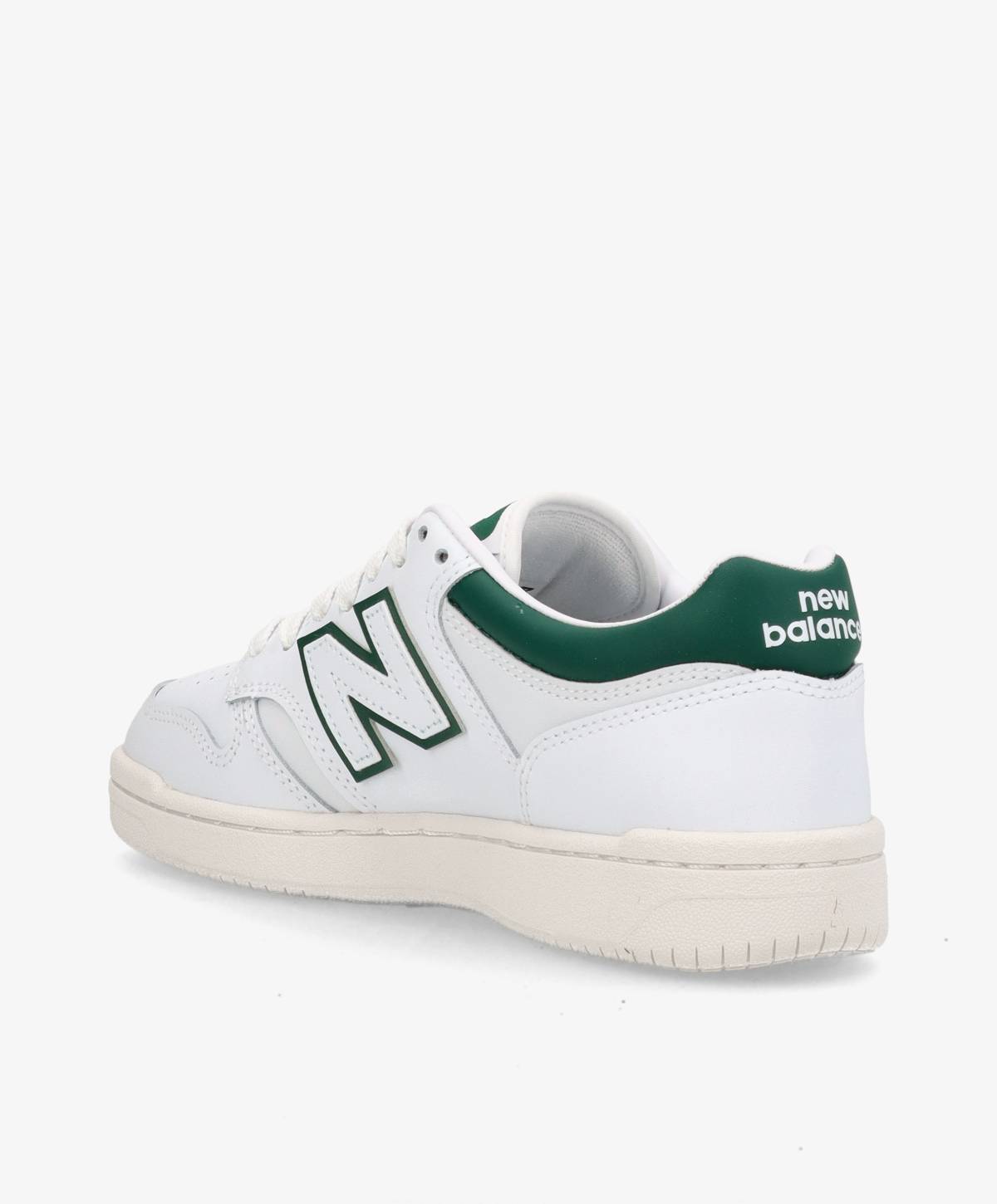 Hvid sneaker med grønne detaljer og "New Balance" logo på hælen.