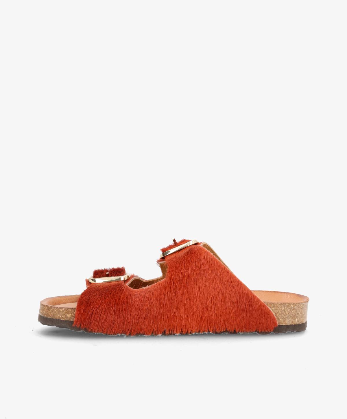 Rød sandal med pelsdetaljer og korksål, set fra siden.