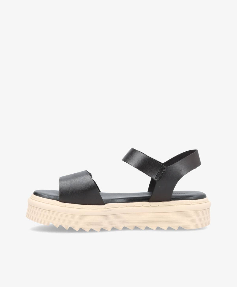 Sort sandal med tyk, beige sål og to remme, set fra siden.