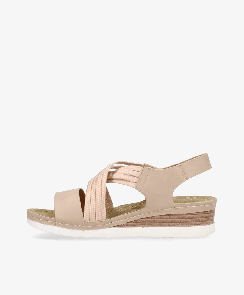 Beige sandal med kilehæl og elastiske stropper, set fra siden mod en hvid baggrund.