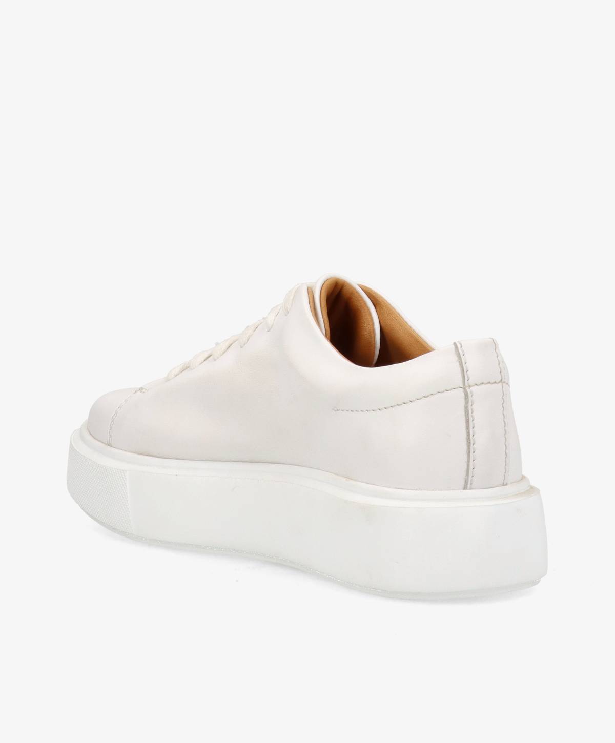 Hvid sneaker set fra siden med en tyk, hvid sål og beige inderside.