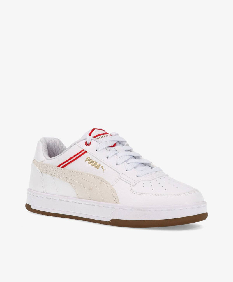 Hvid sneaker med røde og beige detaljer, brun sål og mærket Puma på siden.