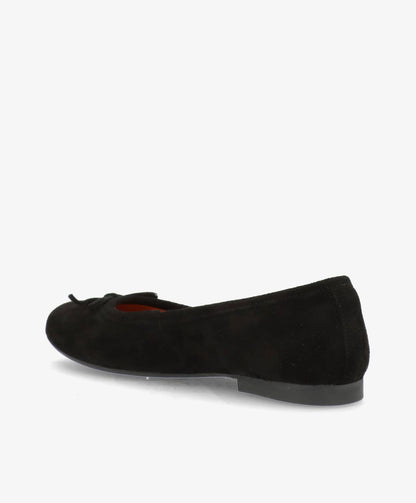 Sort ballerina-sko i ruskind med en lille sløjfe på snuden, set fra siden mod en hvid baggrund.