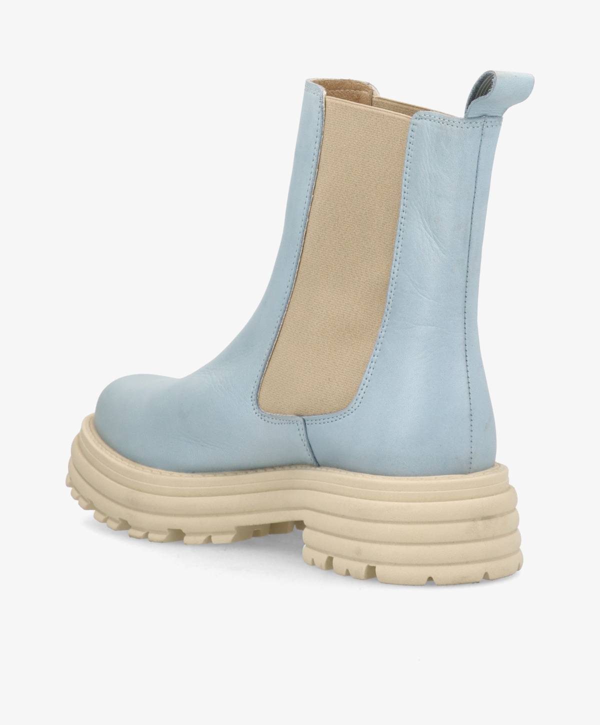 Lyseblå støvle med tyk, beige sål og elastiske sidepaneler.