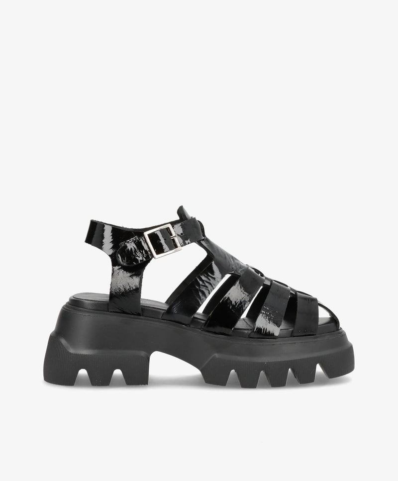 Sort sandal med tyk sål og remme, set fra siden.