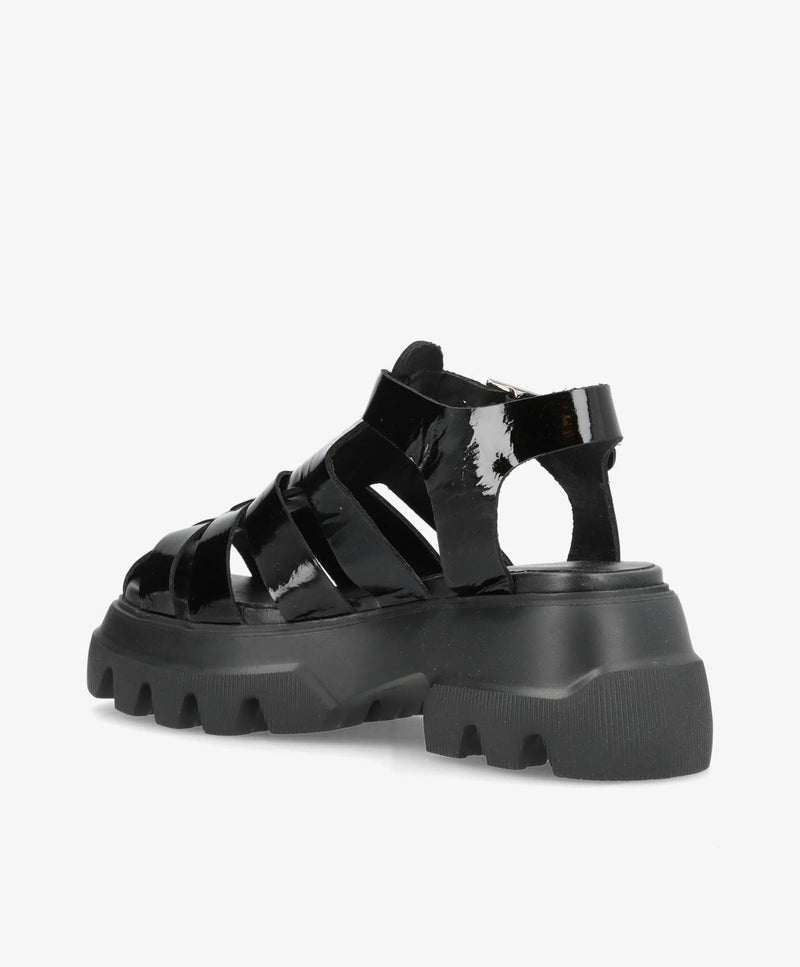 Sort sandal med tyk, rillet sål og flere stropper i skinnende materiale.