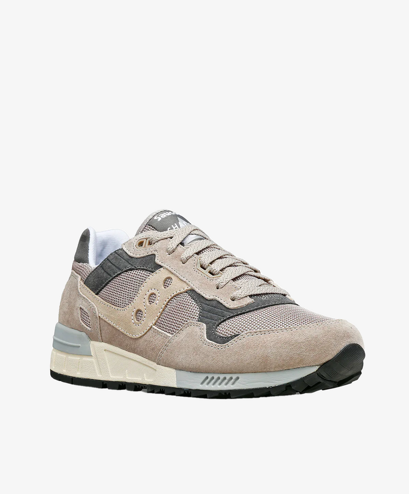 Sneaker til kvinder i lys grå med beige og sorte detaljer, set fra siden.
