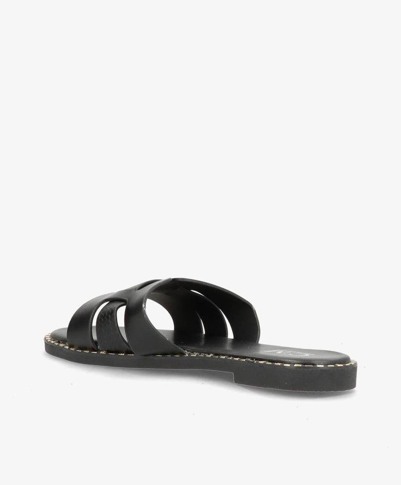 Sort slip-in sandal med flade såler og åbne tåremme, set fra siden.