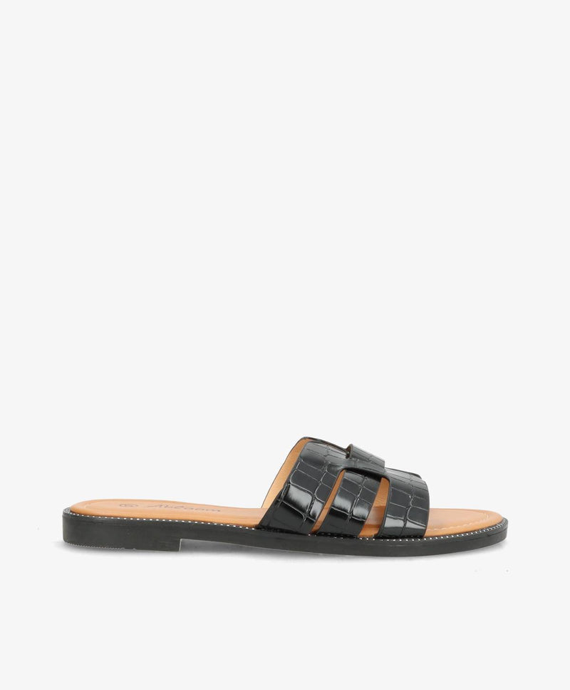 Sort slip-in sandal med krokodillemønster og flad sål.