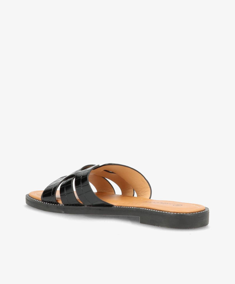 Sort slip-in sandal med flade såler og tre remme i skinnende materiale.