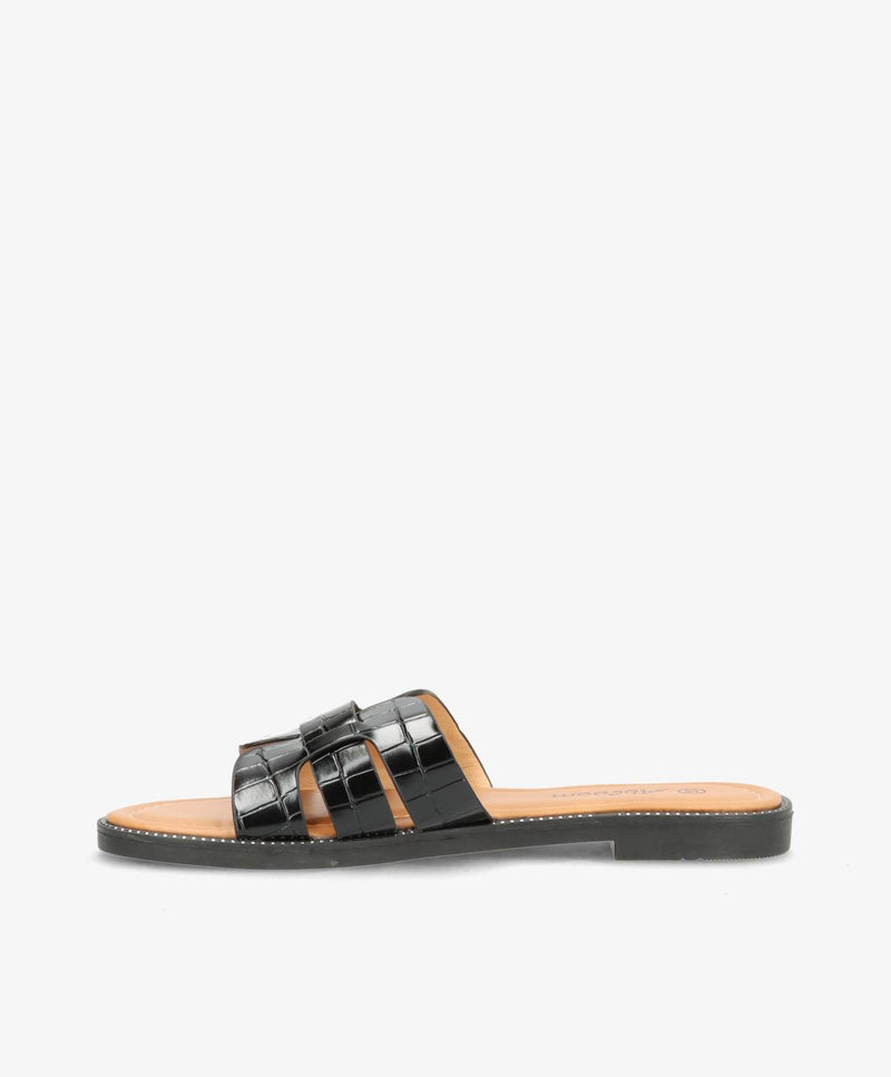 Sort slip-in sandal med flad sål og flettet remdesign.