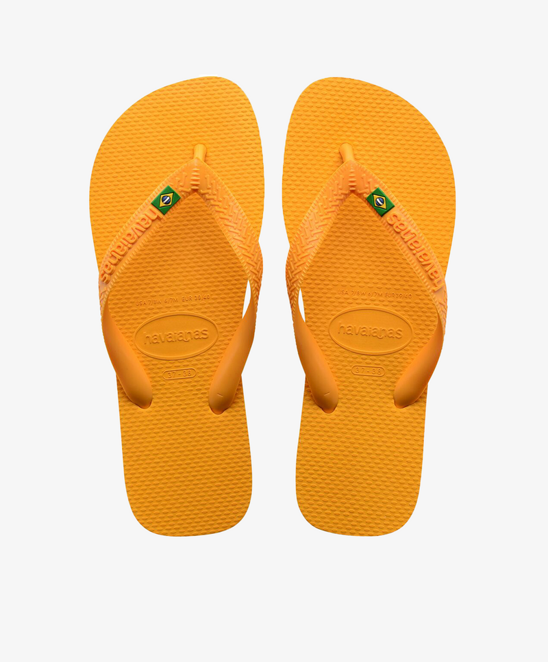 Gule Havaianas slip-ins med logo og brasiliansk flag.